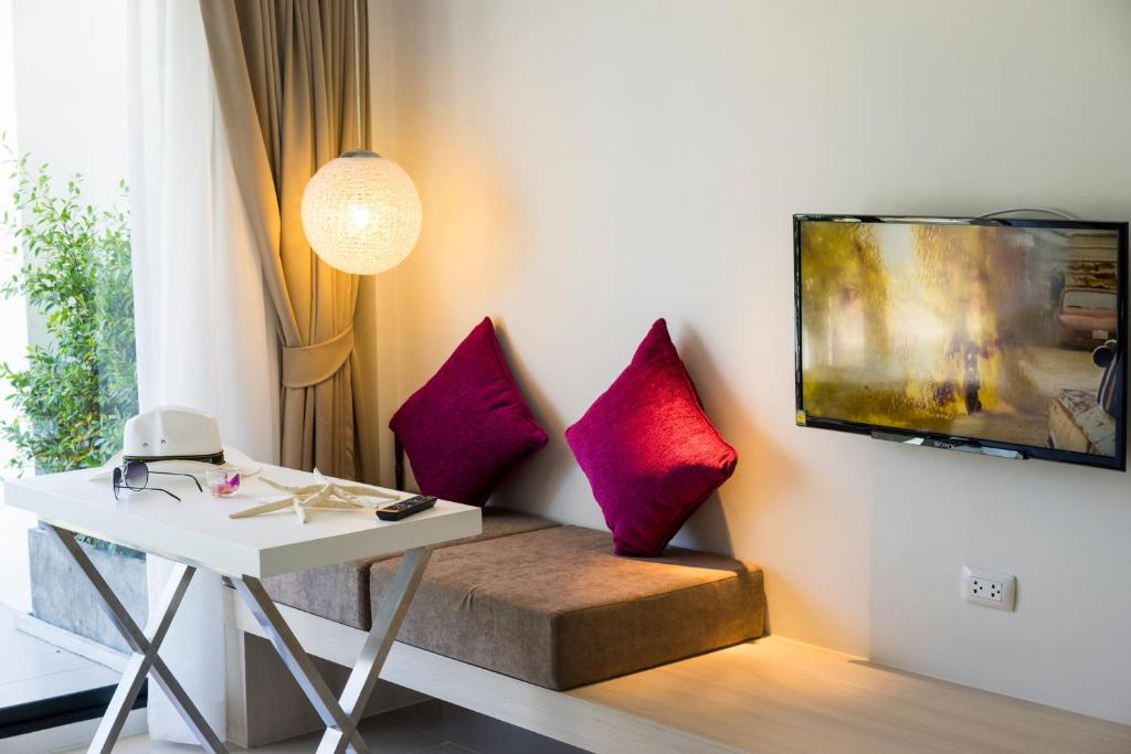 a room with a desk and a table with pillows at Coral Inn in Karon Beach