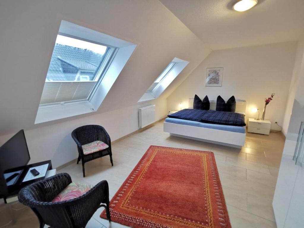een slaapkamer met een bed en 2 stoelen en een tapijt bij Ferienhaus Tönsing in Horumersiel
