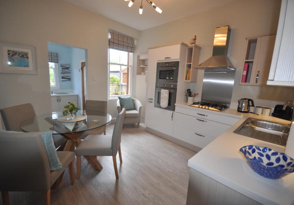a kitchen and living room with a table and a dining room at Links Corner in Gullane