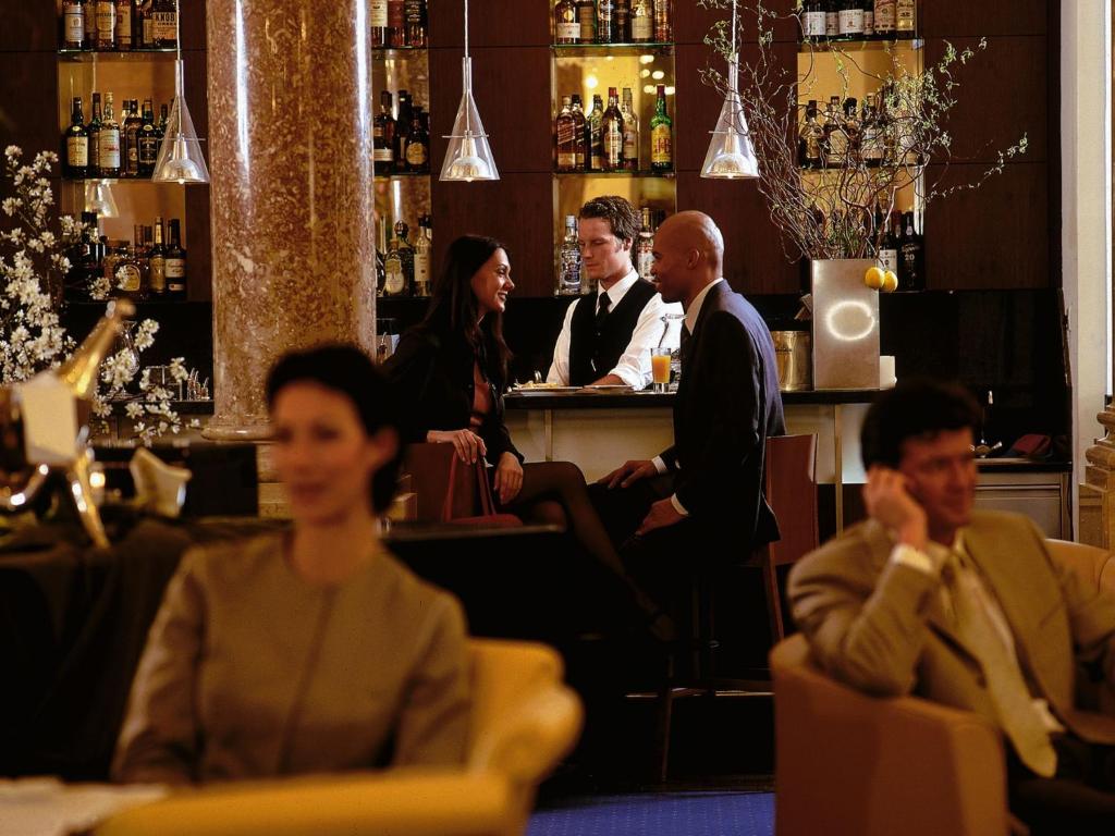 a group of people sitting at a bar at Hotel Ambassador in Vienna