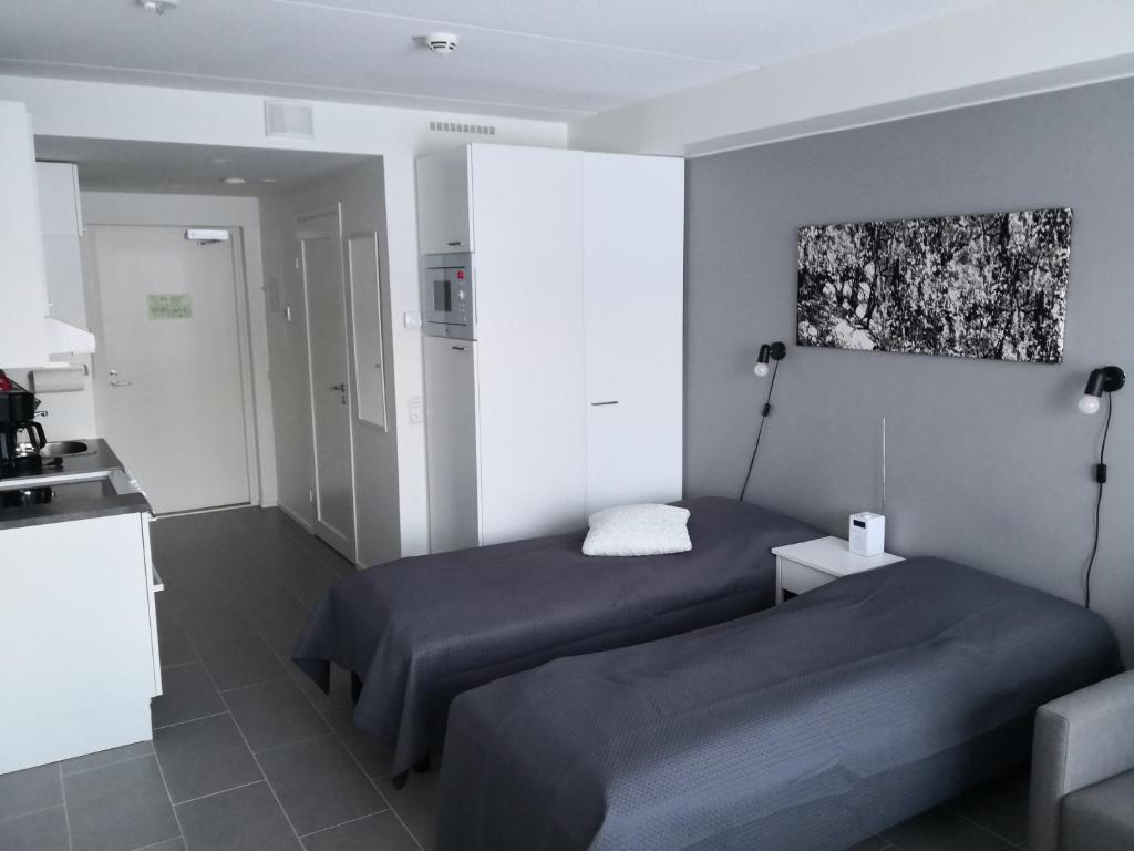 Dormitorio pequeño con 2 camas y cocina en Levi Ski-Star 220, en Levi