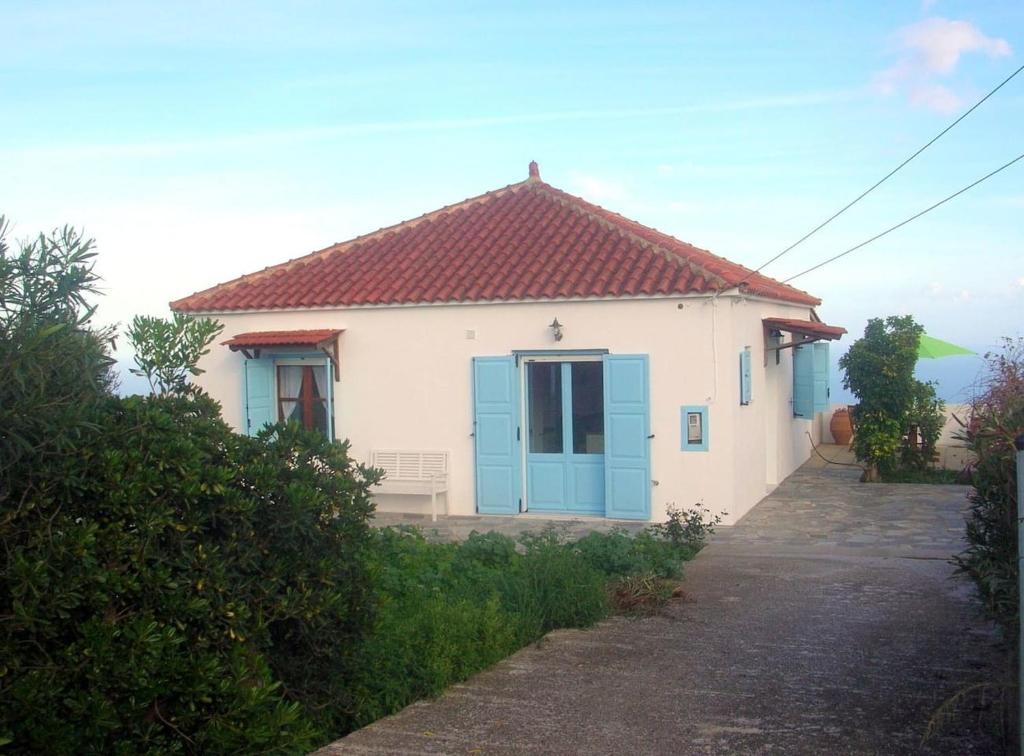 a small white house with a blue door at Kefalas nr Almyrida sea view cottage in Chania