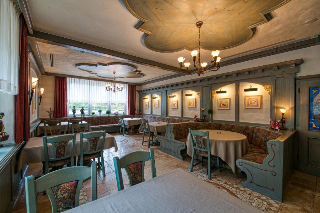 a restaurant with tables and chairs in a room at Hotel Haus Tiefenbach in Bullange