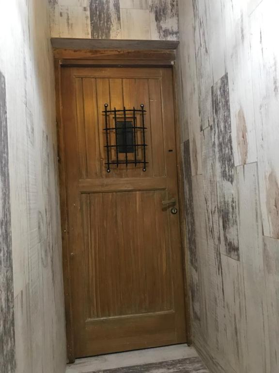 una puerta de madera con una rejilla metálica en Casa Laura Bariloche en San Carlos de Bariloche