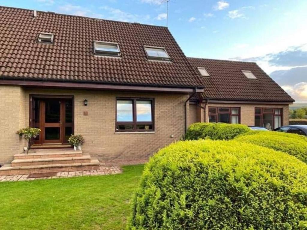 een huis met groene struiken ervoor bij Lovely 1-Bed House in Stirling in Stirling