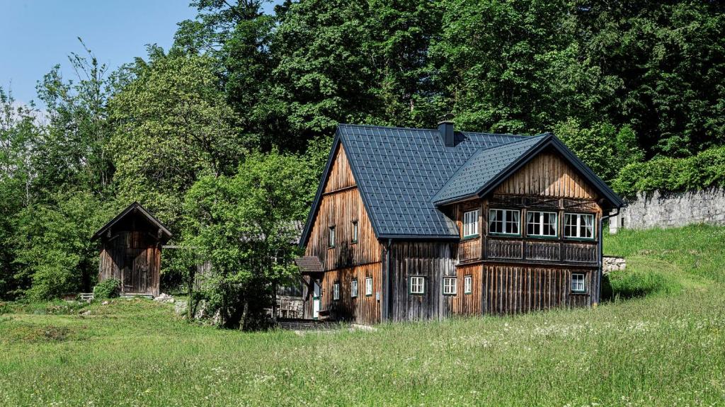 グルントルゼーにあるDas Haus am Grundlseeの田地の丘の上の古木造家屋