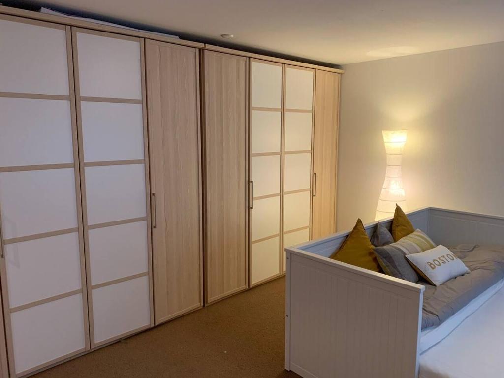 a bedroom with white cabinets and a bed with pillows at Charming 2-Bed Apartment in Arlesheim 15 min Basel in Arlesheim
