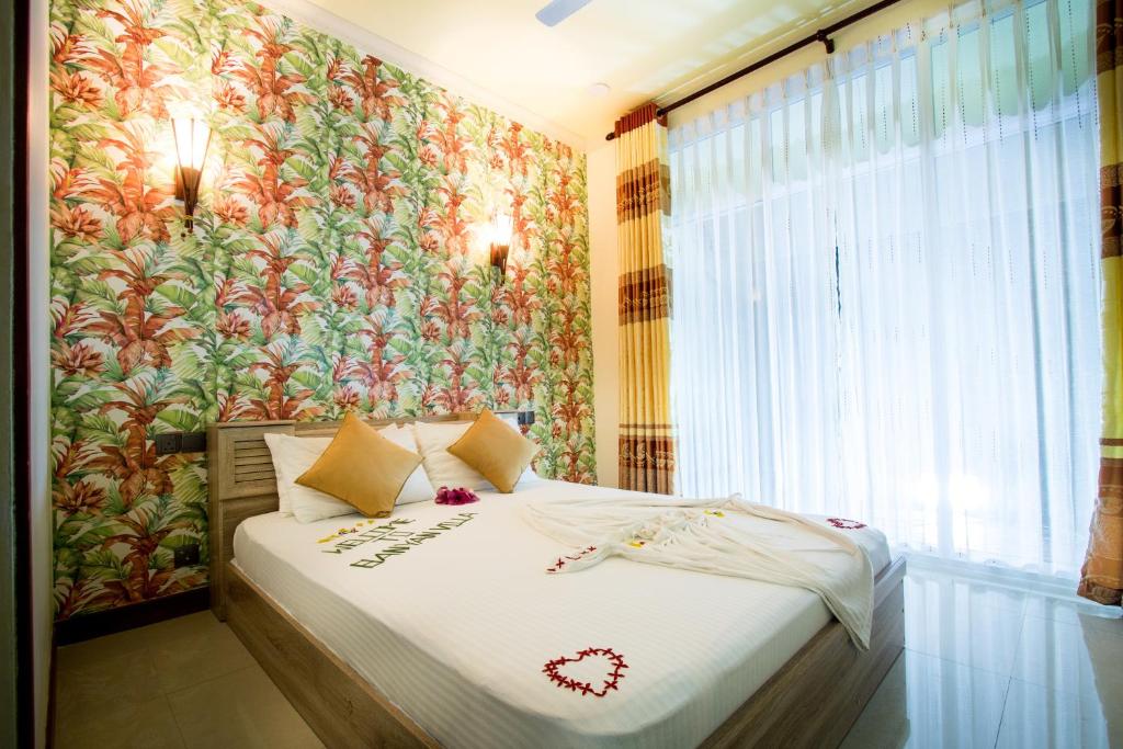 a bedroom with a bed with a floral wallpaper at Banyan Villa Maldives Dhangethi in Dhangethi