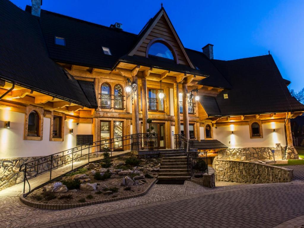 a large building with a garden in front of it at Apartament Zacisze pod Giewontem in Zakopane