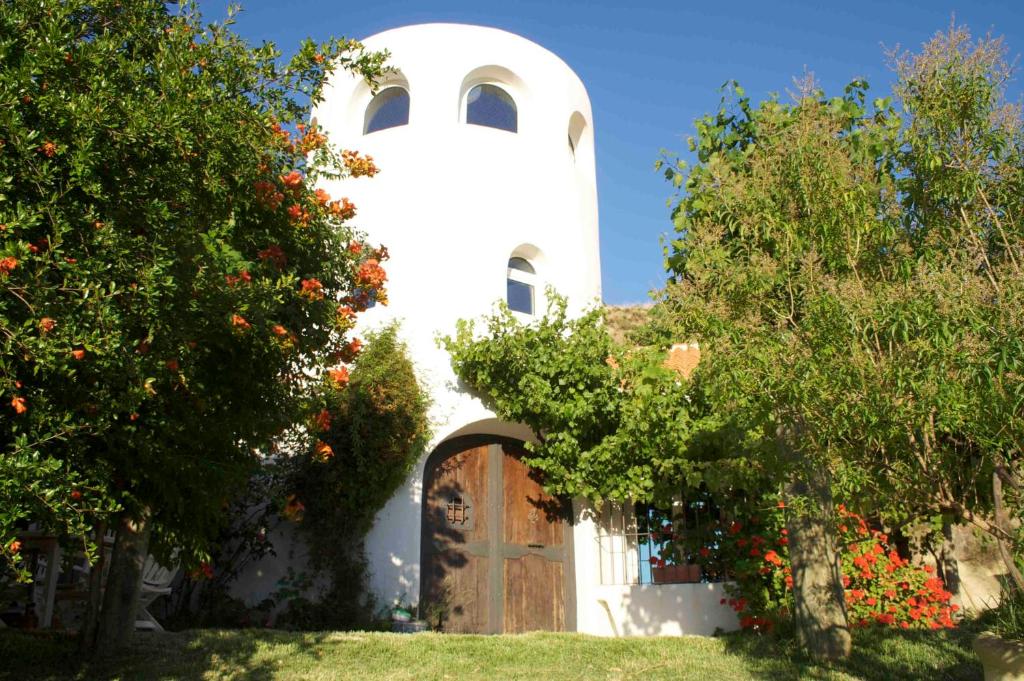 un edificio bianco con una porta e alcuni alberi di Melegis 4-Bed Villa Sleeps 7 Pool & Garden a Melegis