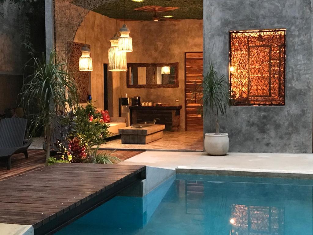 a house with a swimming pool and a living room at Little Gem Hotel Tulum La Veleta in Tulum