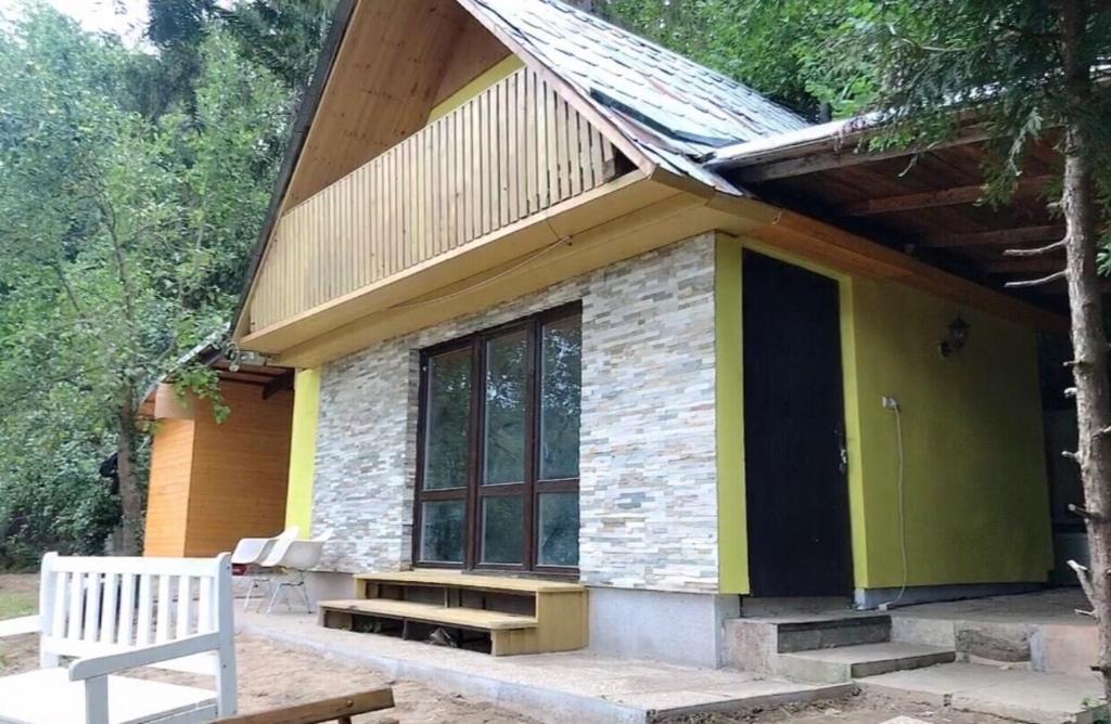 ein kleines Haus mit einer Bank davor in der Unterkunft Sazava River Cottage with boating experience in Týnec nad Sázavou
