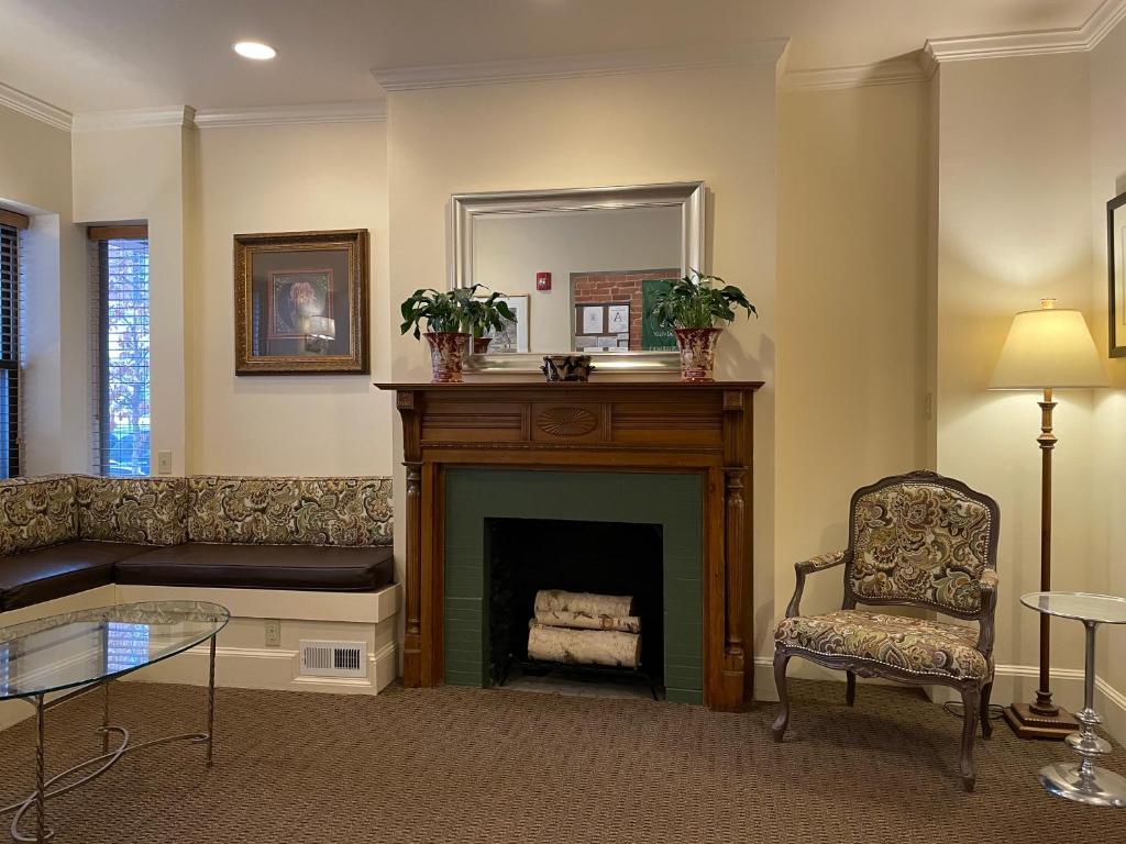 a living room with a fireplace and a chair at Oasis Guest House in Boston