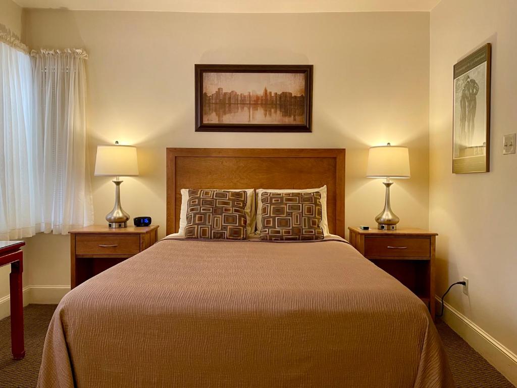 Oasis Guest House في بوسطن: غرفة نوم بسرير كبير فيها مصباحين