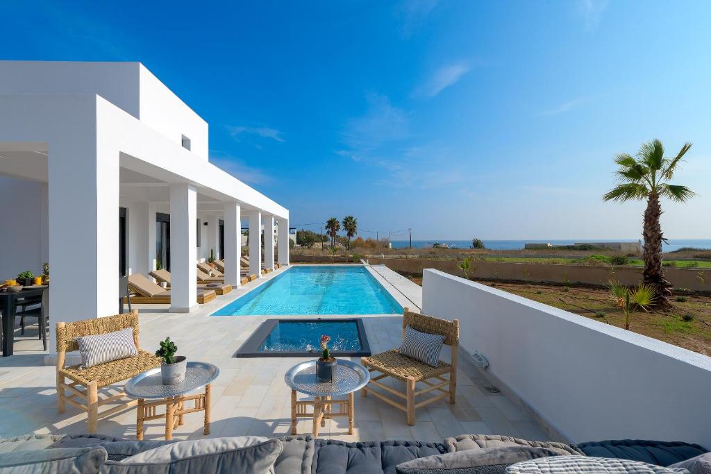 a villa with a swimming pool and a patio at Seawater Villa in Lachania