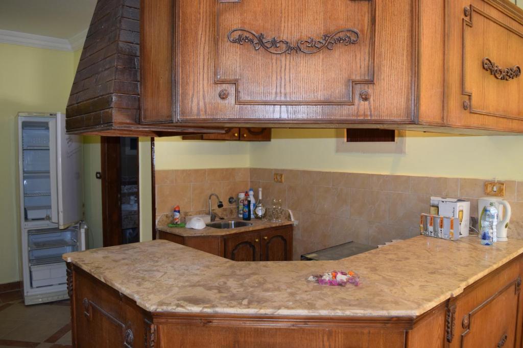 a kitchen with wooden cabinets and a granite counter top at apartment with separate entrance near Arabia hotel in Hurghada
