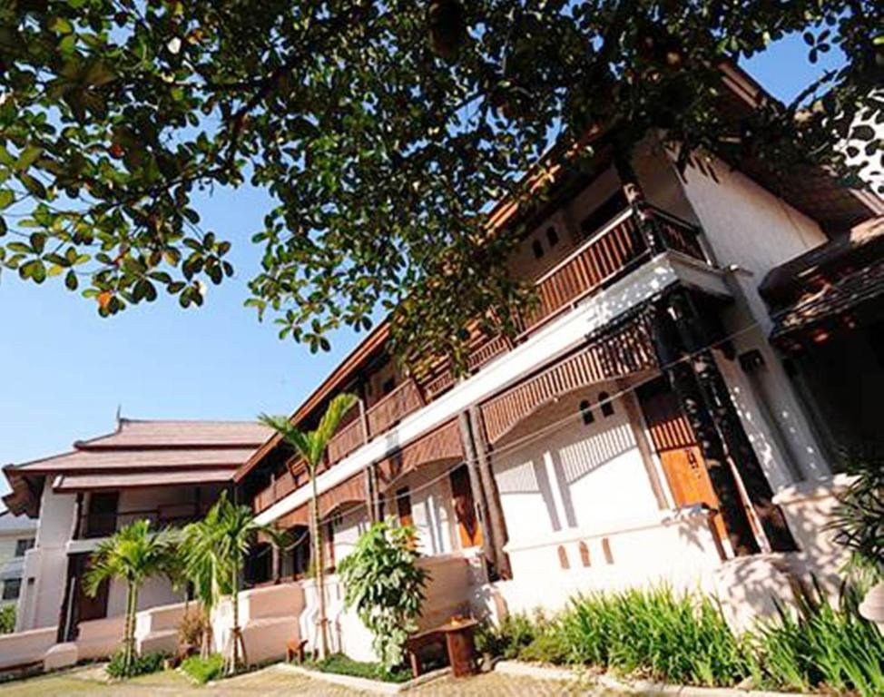un bâtiment avec une clôture sur son côté dans l'établissement Villa Korbhun Khinbua, à Chiang Mai