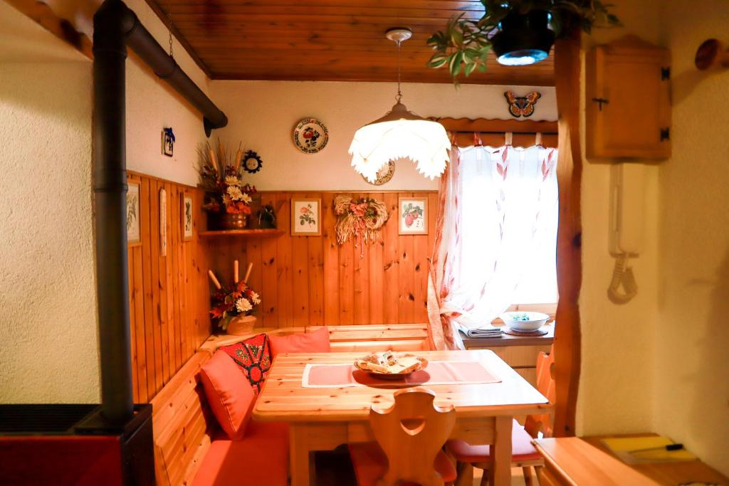 Habitación con mesa de madera y ventana. en TRE CIME FOCOBON - Bellavista sulle Dolomiti en Falcade