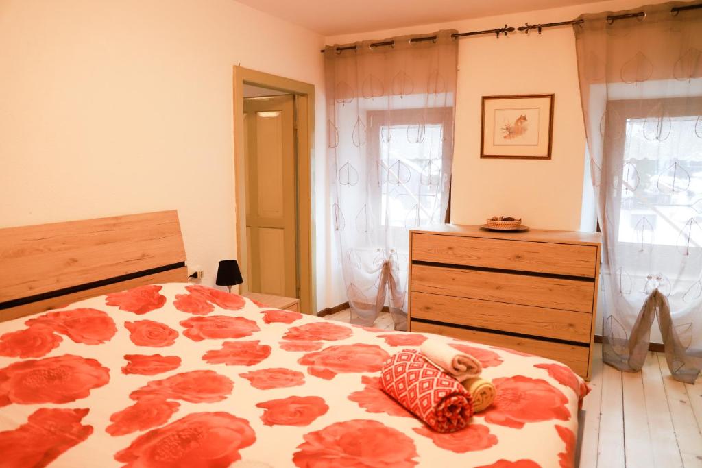 una camera con letto e cassettiera di COL DE RIF Appartamento Storico nelle Dolomiti a Falcade