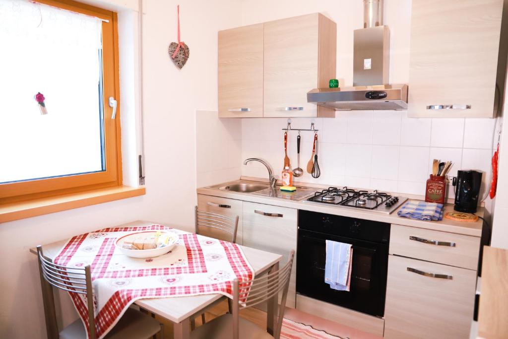 uma pequena cozinha com uma mesa e um fogão em Mountain Chalet Cime d'Auta Dolomiti em Falcade