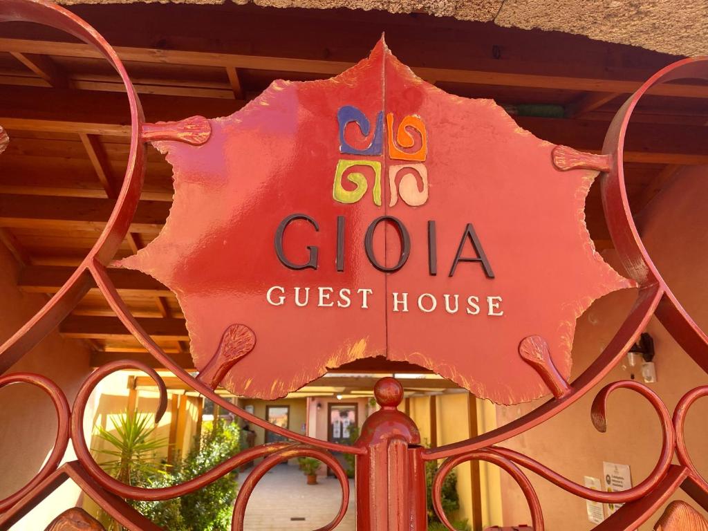 a sign for a guest house on top of a gate at Gioia Guesthouse in Càbras