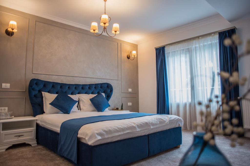 um quarto com uma cama azul e uma janela em Boga Rooms em Sinaia