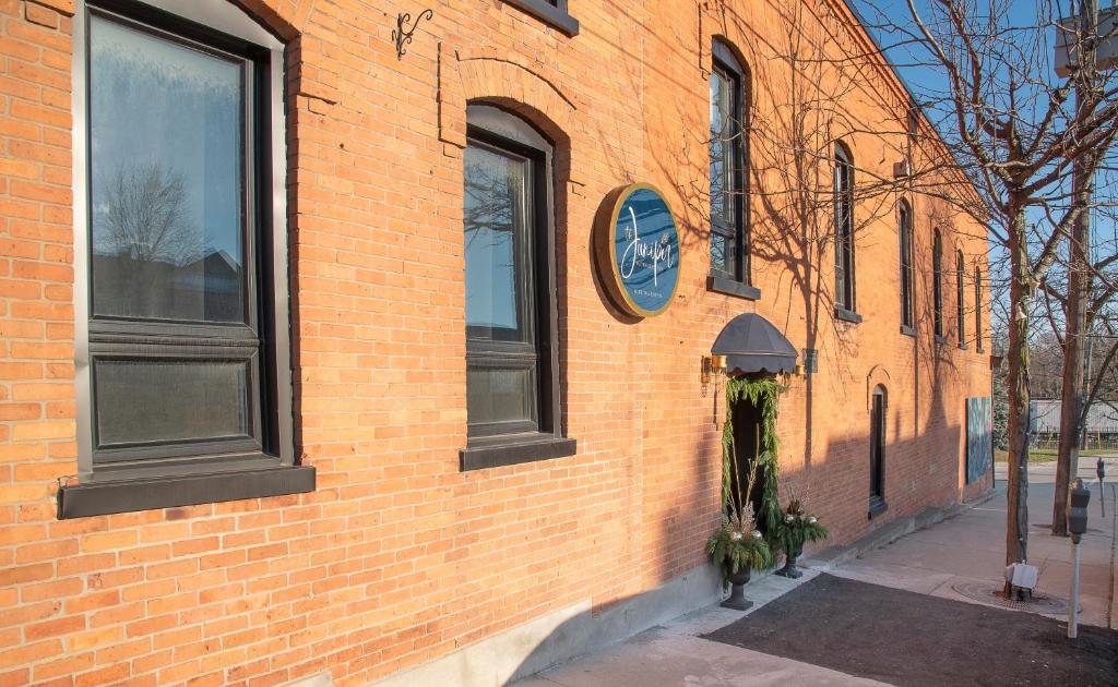 un edificio de ladrillo con un reloj a un lado en The Juniper Inn en Saint Catharines