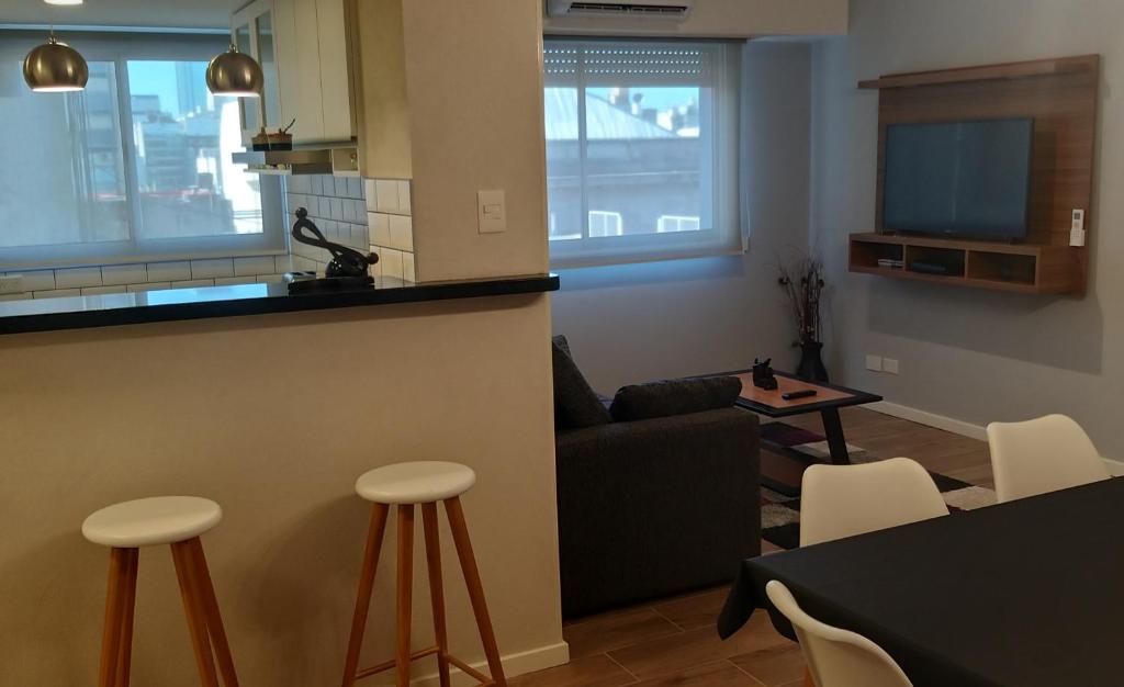 een keuken en een woonkamer met een bank en stoelen bij Moderno departamento en San Telmo in Buenos Aires