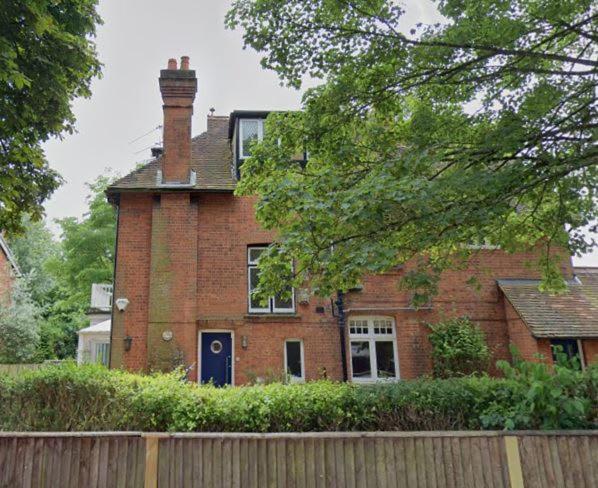 a brick house with a blue door and a fence at Maidenhead - Stylish 4 bedroom apartment in Maidenhead