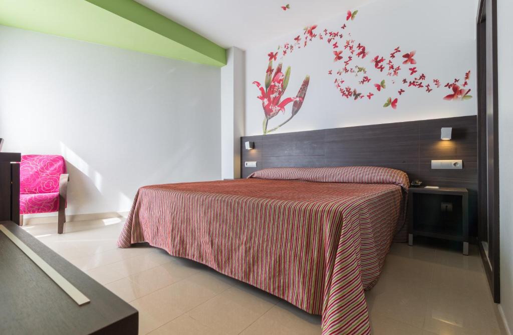 a bedroom with a bed with a red blanket at Hotel Porto Calpe in Calpe