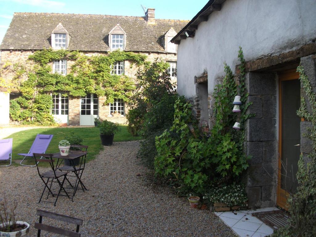 a courtyard of a house with a table and chairs at La Clef du Four in Plesder