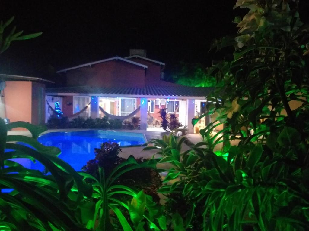 ein Haus mit Swimmingpool bei Nacht in der Unterkunft Casa de Praia Planeta Guarajuba in Guarajuba