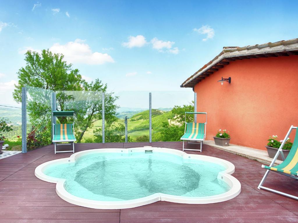 een hot tub op een terras met 2 stoelen bij Belvilla by OYO Borgo Tre in SantʼAngelo in Vado