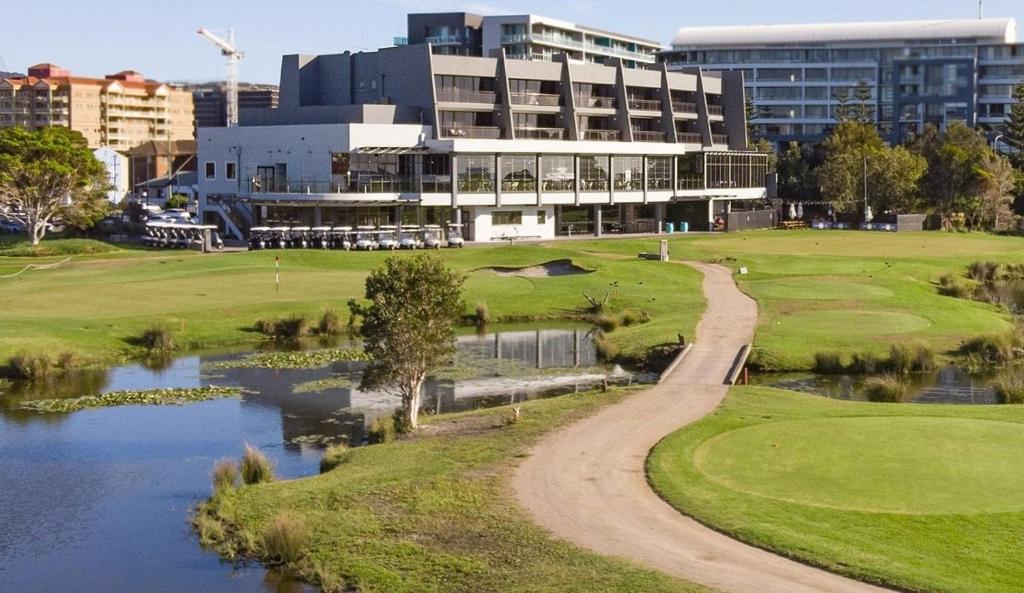 a view of a golf course with a building at Best Western City Sands in Wollongong