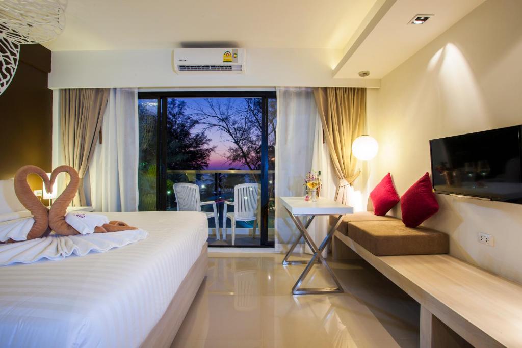 a hotel room with a bed and a television at Coral Inn in Karon Beach