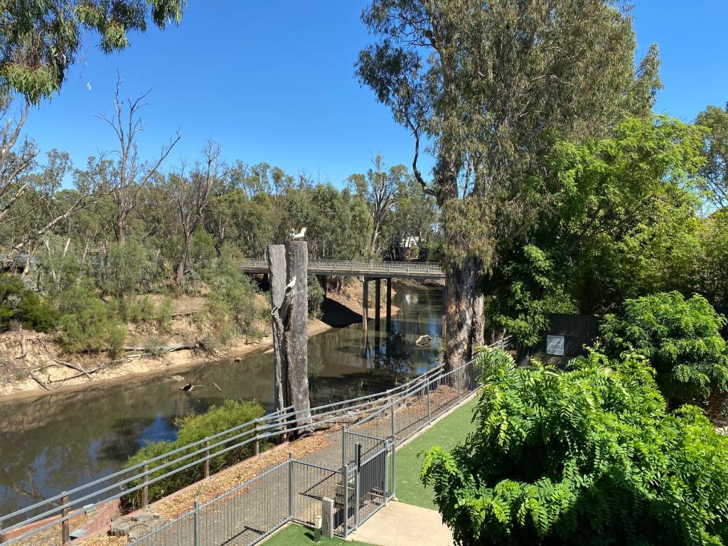 a bridge over a river next to a forest at Adelphi Apartments 3 or 3A - Downstairs 2 Bedroom or Upstairs King Studio with Balcony in Echuca