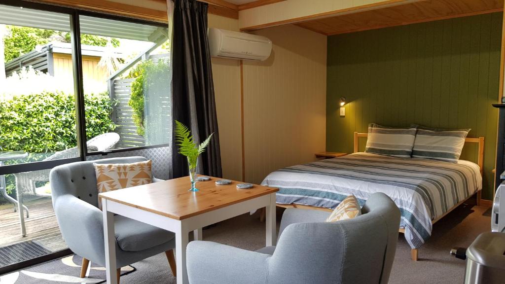 1 dormitorio con 1 cama, mesa y sillas en Peak Sport Chalet en Wanaka