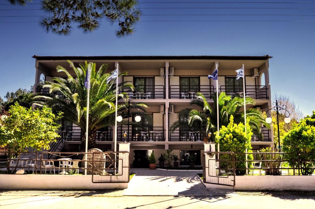 un edificio con palme di fronte ad esso di Vlachogiannis Hotel a Prinos