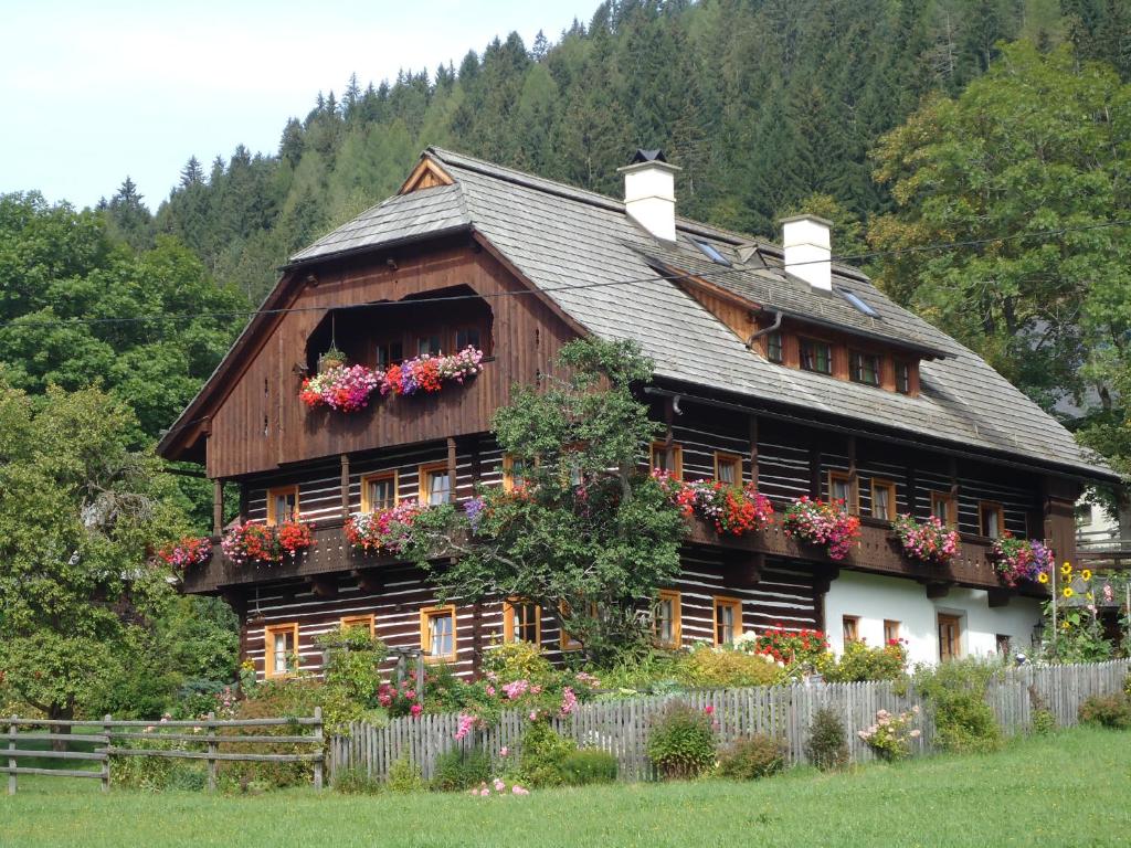 ein großes Holzhaus mit Blumen davor in der Unterkunft Leebhof in Patergassen