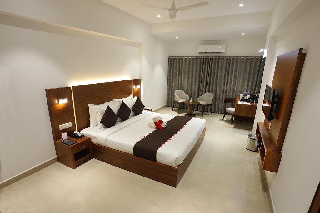 a bedroom with a bed with a teddy bear on it at Iswarya Residency in Kottayam