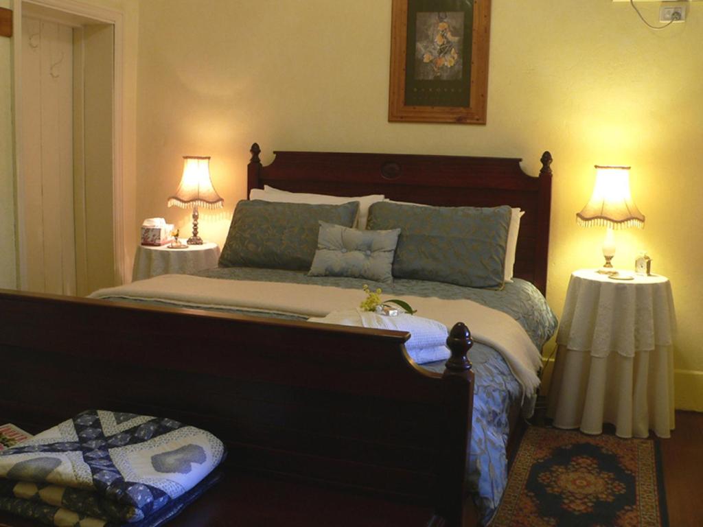 Angaston的住宿－Walnut Cottage，一间卧室配有一张大床和两张桌子