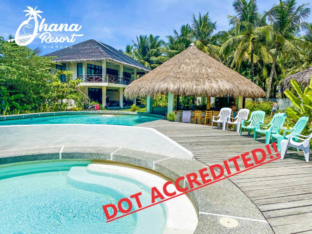 a swimming pool with chairs and a sign that reads donacciated at Ohana Resort Siargao in General Luna