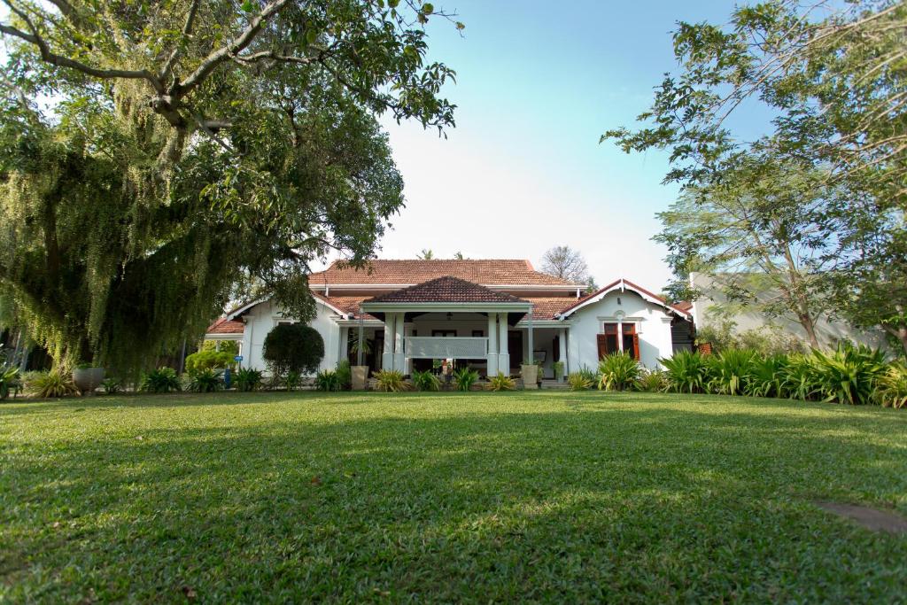 een wit huis met een grote tuin bij Swanee Grand in Negombo