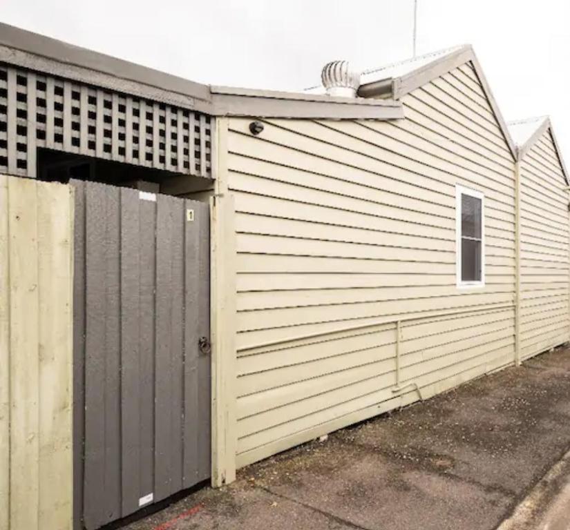 a building with a garage with a door at Quartz Cottage Geelong in Geelong