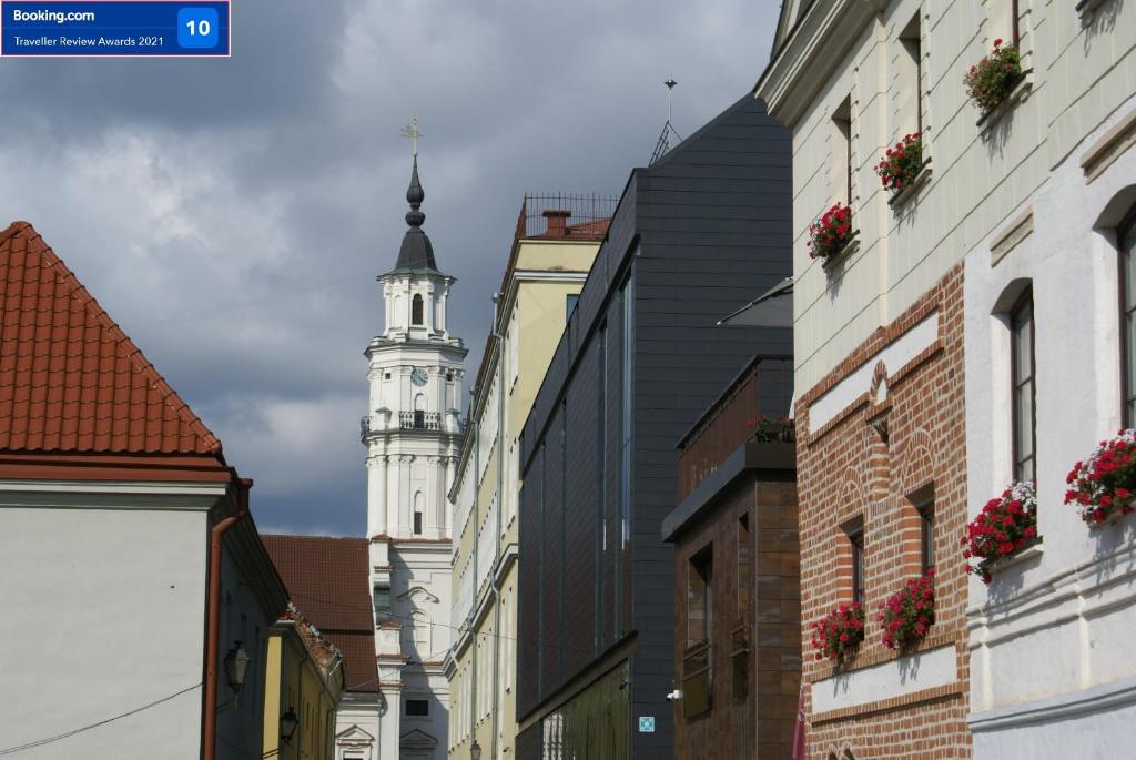 una calle de la ciudad con una torre del reloj en el fondo en Old Town Apartment with a separate entrance en Kaunas
