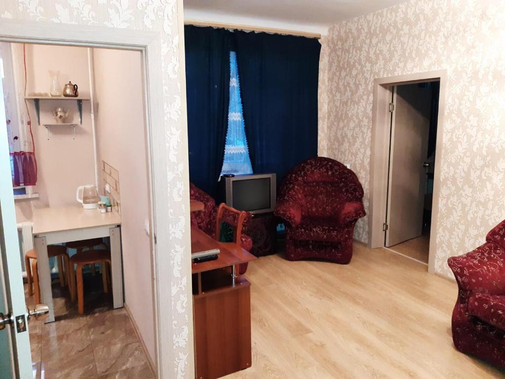 ノヴォシビルスクにあるApartments home hotelのリビングルーム(椅子、テレビ付)