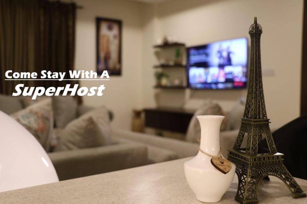 a figurine of the eiffel tower on a table at Elegant & Charming One Bed Apartment In Bahria Town in Rawalpindi