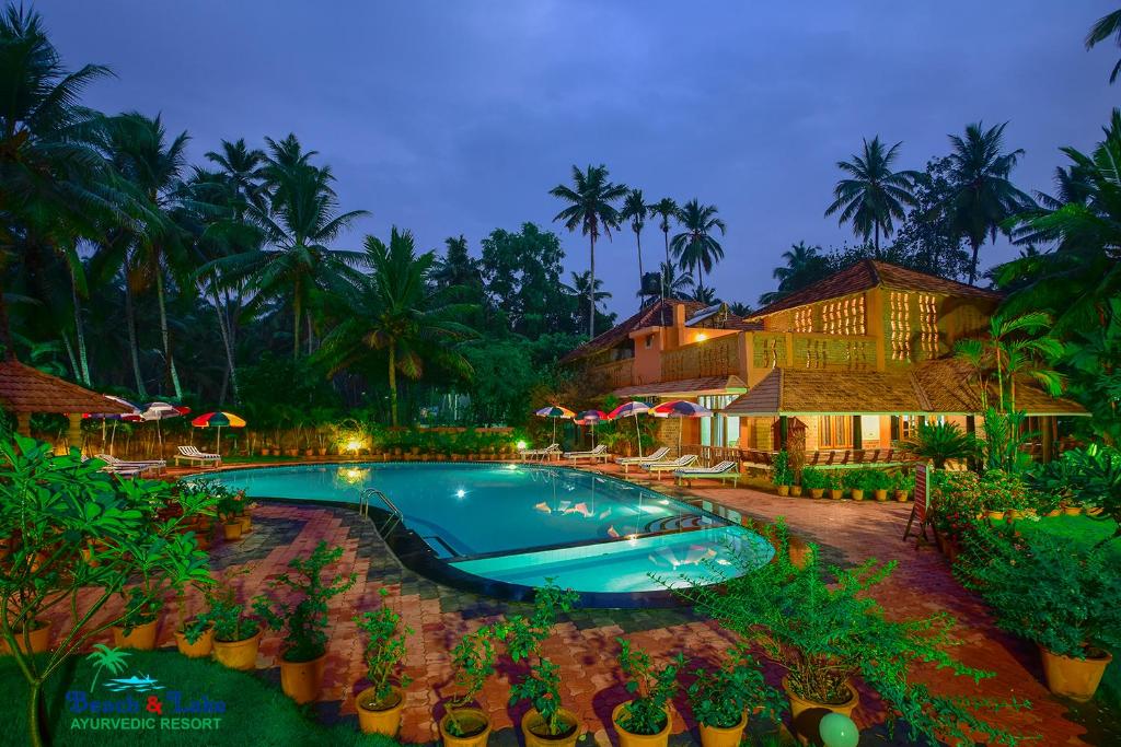 una piscina en un complejo por la noche en Beach and Lake Ayurvedic Resort, Kovalam, en Kovalam