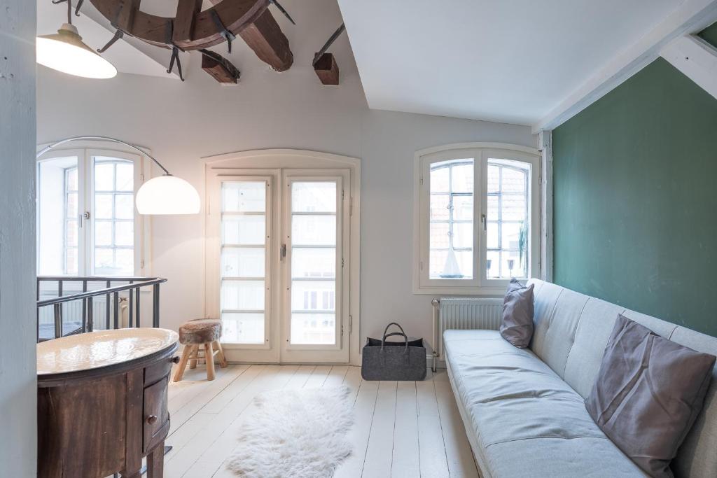 a living room with a couch and a table at Altes Kontorhaus Backbord in Husum