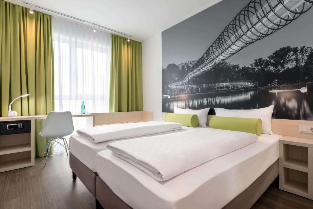 a bedroom with a large bed with a painting on the wall at Super 8 by Wyndham Oberhausen am Centro in Oberhausen